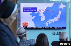 People watch a news report on North Korea firing a ballistic missile, at a railway station in Seoul, South Korea, May 14, 2017.