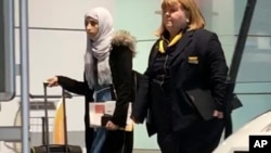 Yemeni national Shaima Swileh, left, walks through the airport in Munich, Germany, Dec. 19, 2018, before boarding a plane to the U.S., where she wants to give her son one more kiss before he dies.