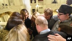 Sobrevivientes de abuso sexual infantil se abrazan en el Capitolio de Pensilvania mientras esperan la legislación para responder a un informe histórico del gran jurado estatal sobre el abuso sexual infantil en la Iglesia Católica, el 17 de octubre de 2018 en Harrisburg, Pensilvania. 