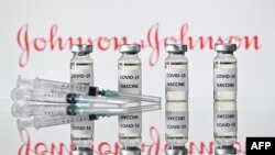 This file illustration photo shows vials with Covid-19 Vaccine stickers attached and syringes with the logo of US pharmaceutical company Johnson & Johnson, November 17, 2020. 