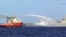 FILE - A Chinese ship (L) shoots a water cannon at a Vietnamese vessel (R) while a Chinese Coast Guard ship (C) sails alongside in the South China Sea, off Vietnam's coast.