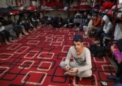 FILE - Prisoners from Iraq and Syria, suspected of being part of the Islamic State, sit inside a prison cell in Hasaka, Syria, Jan. 11, 2020.