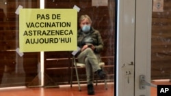 A man waits in a vaccination center where a sign reads "No AstraZeneca vaccinations today" in Saint-Jean-de-Luz, southwestern France, Tuesday, March 16, 2021. 