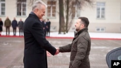 En esta fotografía proporcionada por la Oficina de Prensa Presidencial de Ucrania, el presidente de Lituania, Gitanas Nauseda, izquierda, da la bienvenida al presidente ucraniano Volodymyr Zelenskyy en el patio presidencial, Vilnius, Lituania, el 10 de enero de 2024.