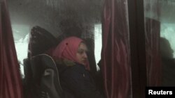 People evacuated from the two villages of Kefraya and al-Foua, after an agreement reached between rebels and Syria's army, ride a bus at insurgent-held al-Rashideen, Aleppo province, Syria, April 14, 2017. 