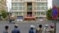 FILE - Security personnel stand across the street in front of Phnom Penh Municipal Court, Aug. 1, 2020.