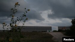 
Seorang petugas patroli perbatasan menjaga sebuah celah di pagar perbatasan AS-Meksiko dekat Texas, 5 April 2018.
