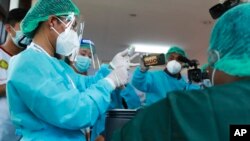 Seorang nakes bersiap menyuntikkan vaksin Covid-19 untuk rekannya di pusat perawatan Covid Ayeyarwaddy di Yangon, Myanmar, 27 Januari 2021. (Foto: dok).