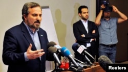 Louay al-Safi, spokesman for the Syrian National Coalition (L), speaks during a news conference in Istanbul May 26, 2013. 