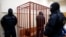 FILE - A defendant stands inside a special cage as he attends a court hearing in Sakhalin, Russia, March 4, 2015. The number of people imprisoned in Russia on extremism-related charges jumped from 137 in 2011 to 414 in 2015, according to independent research.