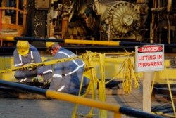FILE - Workers fix the damage in Aramco's oil-processing facility sustained in the Sept. 14 attack in Abqaiq, near Dammam in the Kingdom's Eastern Province, Sept. 20, 2019.