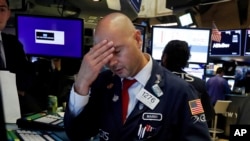 FILE - Specialist Mario Picone works on the floor of the New York Stock Exchange, Wednesday, Aug. 14, 2019. 