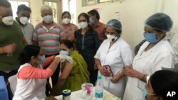 A health worker administers a dose of the Covishied vaccine for COVID-19 at Railway hospital in Prayagraj, India, June 26, 2021. 