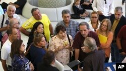 FILE - People inquire about temporary positions available for the 2020 Census during a job fair designed for people fifty years or older in Miami, Sept. 18, 2019. 