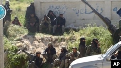 This image posted on the Twitter page of Syria's al-Qaida-linked al-Nusra Front shows fighters from the group in the town of Jisr al-Shughour, Idlib province, Syria, April 25, 2015.