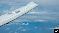 FILE - A U.S. reconaissance plane flies near Chinese structures on the man-made Fiery Cross Reef in the South China Sea, on March 20, 2022. The U.S. and China held talks this week in an effort to stabilize military ties and avoid misunderstandings in the Indo-Pacific region.