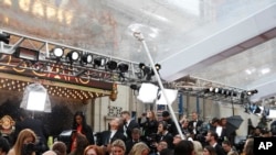 Academy staff clears rain water from above the red carpet, as guests arrive, at the Oscars, at the Dolby Theatre in Los Angeles, California, Feb. 9, 2020. 