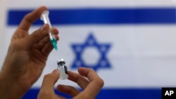 Seorang paramedis militer Israel menyiapkan vaksin Pfizer COVID-19, untuk diberikan kepada orang lanjut usia di sebuah pusat medis di Ashdod, Israel selatan, Kamis, 7 Januari 2021. (Foto: AP/Tsafrir Abayov)