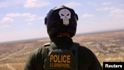 A U.S. Border Patrol agent, wearing a helmet while riding an ATV, searches for migrants trying to enter the United States from the Mexico border in a desert area in Sunland Park, New Mexico, on Aug. 17, 2023.