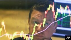 FILE - Specialist Michael O'Mara works on the floor of the New York Stock Exchange, Aug. 25, 2015.