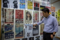 FILE - Apple Daily editor-in-chief Ryan Law points to a copy of the first newspaper front page in the newsroom in Hong Kong, May 13, 2021.