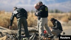 Investigators from the National Transportation Safety Board (NTSB) look at wreckage from the crash of Virgin Galactic's SpaceShipTwo near Cantil, California, Nov. 2, 2014. 