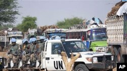 Rwandan troops with the UN-African Union peacekeeping operation in Darfur [UNAMID] escort returnees during a repatriation operation for more than 200 displaced families returning from Aramba to their original village in Sehjanna, north Darfur, Sudan, July