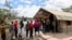 FILE - People stand in line to receive a COVID-19 vaccine, at the Narok County Referral Hospital, in Narok, Kenya, Dec. 1, 2021. 