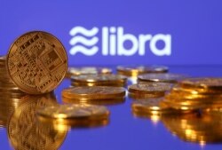 FILE - Representations of virtual currency are displayed in front of the Libra logo in this illustration picture.