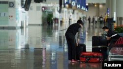 一位女乘客在香港国际机场整理行李（资料照：2020年10月20日）