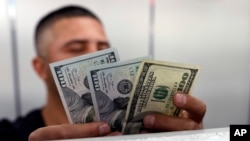 FILE - The Dow Jones Industrial Average is displayed after the closing bell on the floor of the New York Stock Exchange (NYSE) in New York City, March 5, 2020. 