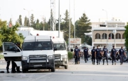 Police officers walk near the parliament building in Tunis, Tunisia, July 26, 2021.