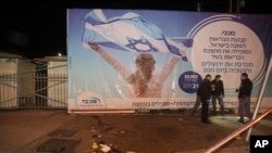 Israeli police officers inspect the scene of an attack in Jerusalem, early Thursday, Feb. 6, 2020, after a Palestinian motorist slammed his car into a group of Israeli soldiers.