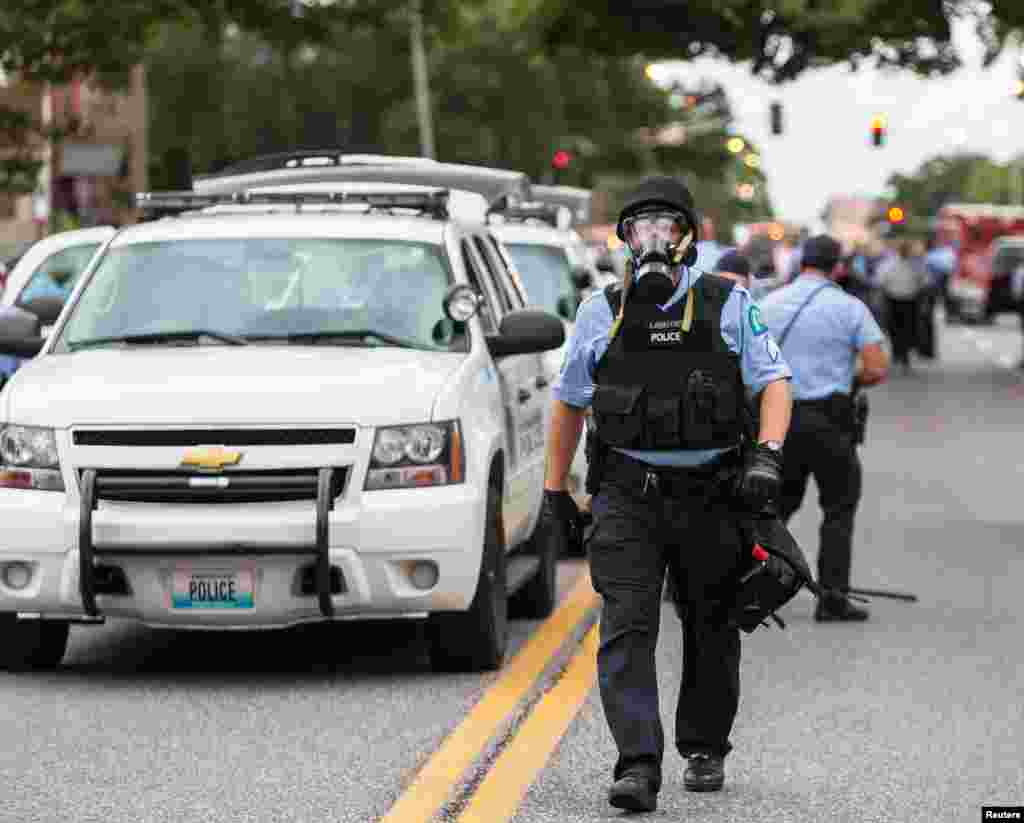 Police wear gas masks as they attempt to disperse a crowd that gathered after a shooting incident in St. Louis, Missouri Aug. 19, 2015.&nbsp;