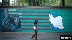 FILE - A man walks past an anti-U.S. mural in Tehran, Iran, Oct. 13, 2017.