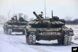 俄罗斯国防部新闻局公布的照片显示俄罗斯坦克在参加演习期间行驶在俄罗斯列宁格勒州的路上。(2022年2月14日)