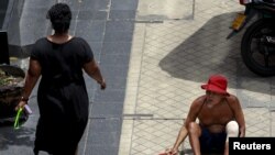 FILE - A man begs for money in central Bangkok, Thailand, May 22, 2015.