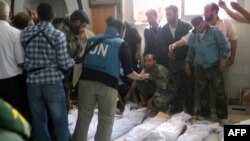Handout photo released by Syrian opposition's Shaam News Network shows UN observers at hospital morgue before their burial in central Syrian town of Houla on May 26, 2012.
