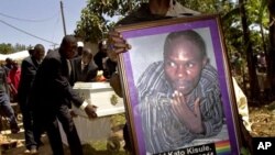 A member of the Ugandan gay community carries a picture of murdered gay activist David Kato during his funeral near Mataba, January 28, 2011. Although the police claims it was most likely a petty crime, targeting Kato's money, many members of the gay and