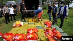 An Indonesian policeman checks crystal methamphetamine from China after a raid at Anyer beach in Serang, Banten province, Indonesia, July 13, 2017. Antara Foto/Asep Fathulrahman via REUTERS