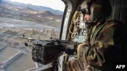 পূর্বাঞ্চলীয় পাকতিকা প্রদেশের বার্মাল জেলায় পাকিস্তনের বিমান আক্রমণের দু দিন পর তালিবান নিরাপত্তা কর্মীরা একটি হেলিকপ্টার থেকে নজরদারি করছেন।
