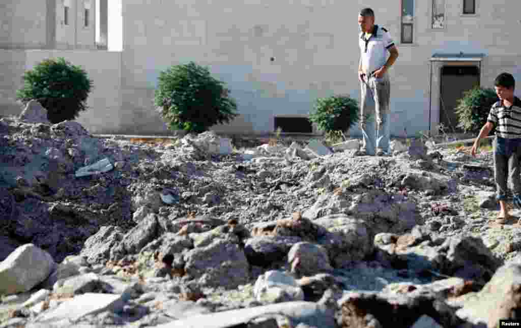 Residents inspect the damage after what was said to be an air raid by Syrian government forces near Azaz, September 3, 2012.