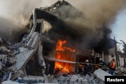 Palestinian firefighters work to extinguish a fire in a house after an Israeli strike in Khan Younis, Gaza, on Dec. 9, 2023.