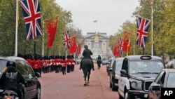 China's national flags are seen fixed on poles beside Union flags along The Mall near Buckingham Palace in London, Oct. 16, 2015, in anticipation of a state visit by Chinese President Xi Jinping and by his wife Peng Liyuan.