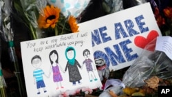 A message card is placed at a collection of flowers left at the Botanical Gardens in Christchurch, New Zealand, March 16, 2019. 