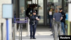 A U.S. security guard stands outside the U.N. European headquarters in Geneva, Switzerland, Dec/ 10, 2015. Geneva officials said Thursday they had raised the level of alert and were looking for suspects by identified by Swiss federal authorities. 