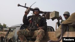 Congolese government army soldiers ride on their truck as they patrol Kibati village outside the eastern Congolese city of Goma, DRC, July 22, 2013. 