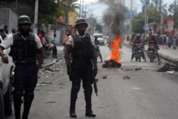Police stand near a barricade built by protesters in Port-au-Prince, Haiti, Sept. 30, 2019.