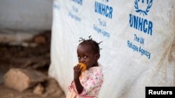 FILE - A girl eats a mango at a shelter for displaced people in Bangui, Central African Republic, April 24, 2017. 