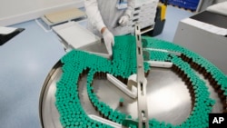 FILE - Laboratory technician at a Sanofi-Pasteur production plant manufacturing Panenza, Val-de-Reuil, western Paris.